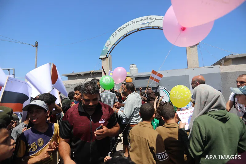 Palestinian children hold helium balloons as they take part in a rally, in the Gaza port, on June 30, 2021. Children from Gaza send messages to the countries of the world, expressing their wishes and aspirations to respe...