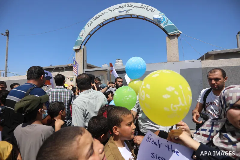 Palestinian children hold helium balloons as they take part in a rally, in the Gaza port, on June 30, 2021. Children from Gaza send messages to the countries of the world, expressing their wishes and aspirations to respe...