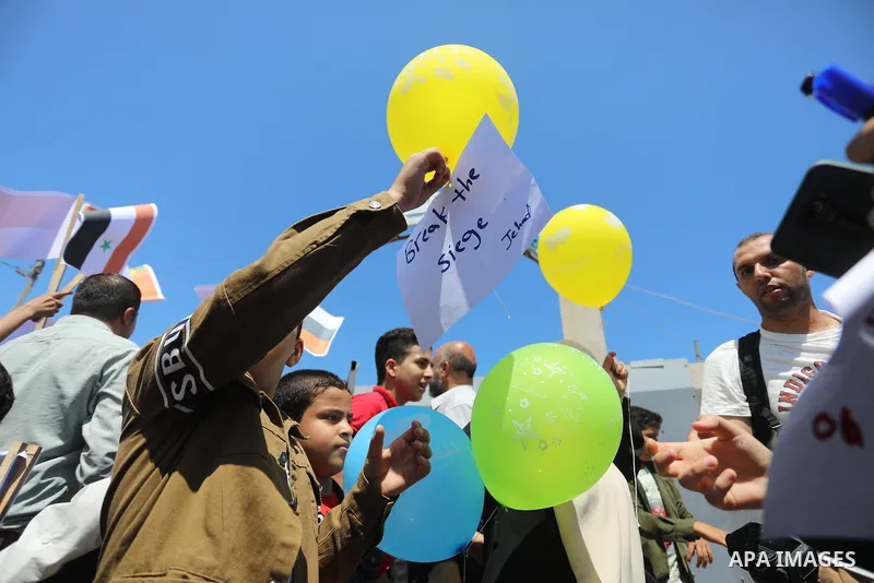 Palestinian children hold helium balloons as they take part in a rally, in the Gaza port, on June 30, 2021. Children from Gaza send messages to the countries of the world, expressing their wishes and aspirations to respe...