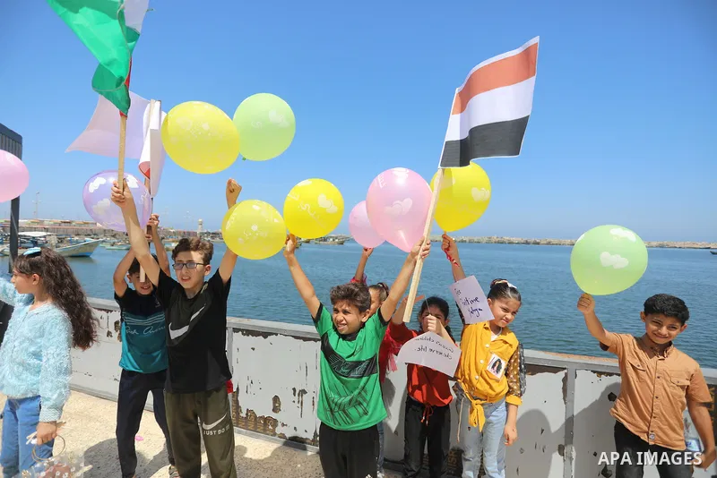 Palestinian children hold helium balloons as they take part in a rally, in the Gaza port, on June 30, 2021. Children from Gaza send messages to the countries of the world, expressing their wishes and aspirations to respe...
