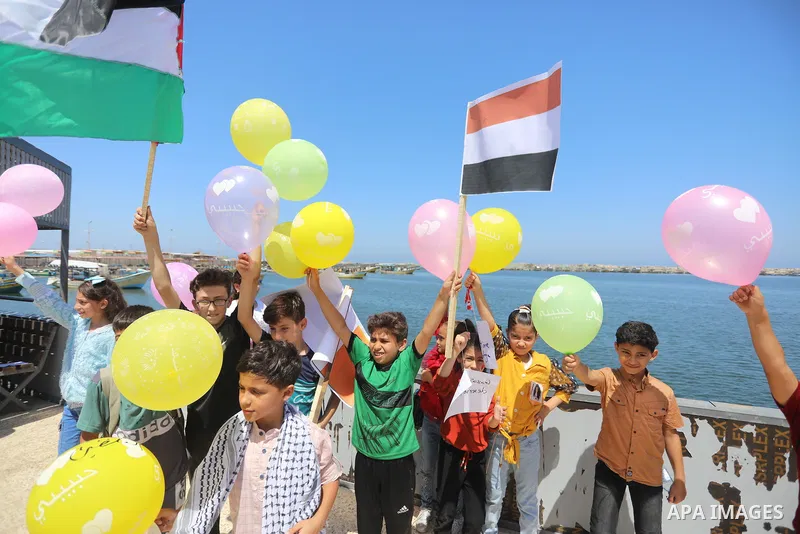 Palestinian children hold helium balloons as they take part in a rally, in the Gaza port, on June 30, 2021. Children from Gaza send messages to the countries of the world, expressing their wishes and aspirations to respe...