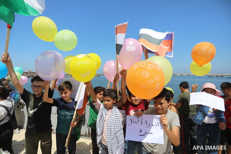 Palestinian children hold helium balloons as they take part in a rally, in the Gaza port, on June 30, 2021. Children from Gaza send messages to the countries of the world, expressing their wishes and aspirations to respe...