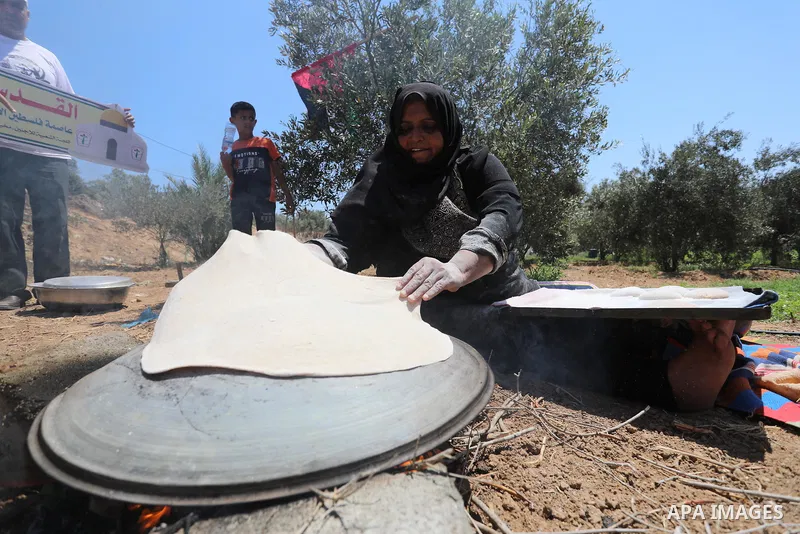 Palestinians take part in an event entitled "The return march is salt of the land and the homeland" near the border fence with Israel, in Maghazi refugee camp in the central Gaza Strip on July 1, 2021. Photo by Ashraf Am...