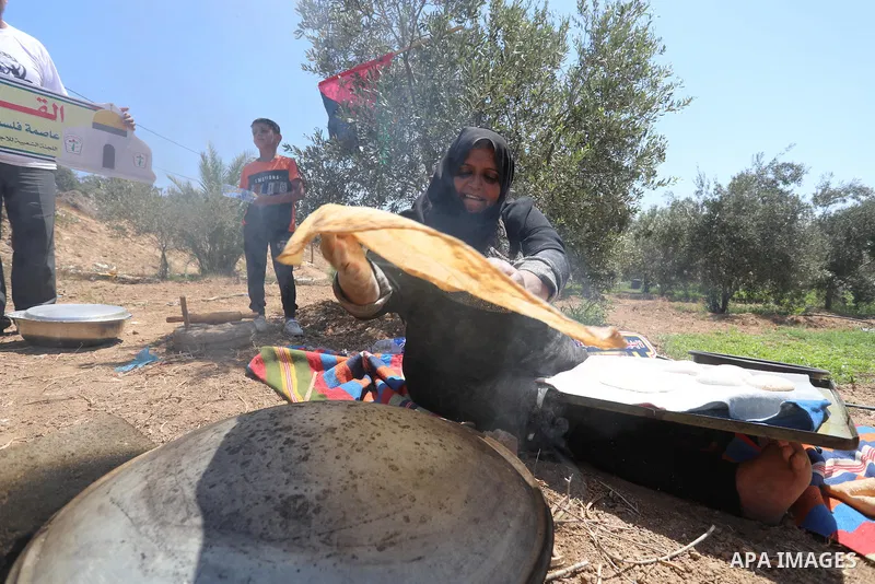 Palestinians take part in an event entitled "The return march is salt of the land and the homeland" near the border fence with Israel, in Maghazi refugee camp in the central Gaza Strip on July 1, 2021. Photo by Ashraf Am...