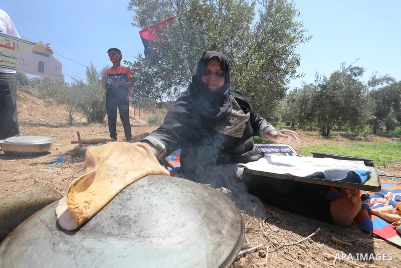 Palestinians take part in an event entitled "The return march is salt of the land and the homeland" near the border fence with Israel, in Maghazi refugee camp in the central Gaza Strip on July 1, 2021. Photo by Ashraf Am...