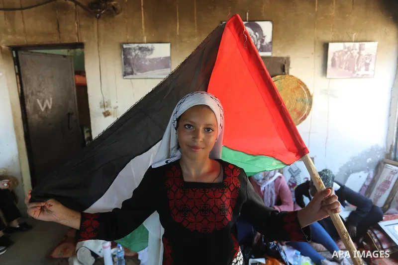 Palestinians take part in an event entitled "The return march is salt of the land and the homeland" near the border fence with Israel, in Maghazi refugee camp in the central Gaza Strip on July 1, 2021. Photo by Ashraf Am...