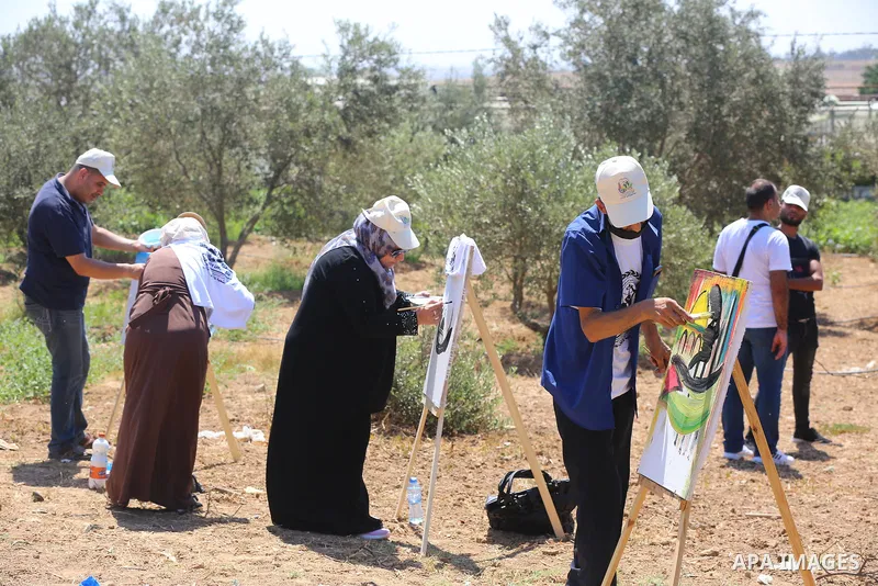 Palestinians take part in an event entitled "The return march is salt of the land and the homeland" near the border fence with Israel, in Maghazi refugee camp in the central Gaza Strip on July 1, 2021. Photo by Ashraf Am...