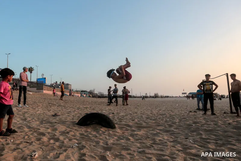 A Palestinian man practises parkour at the beach in Gaza City on July 02, 2021. Photo by Mohammed Dahman