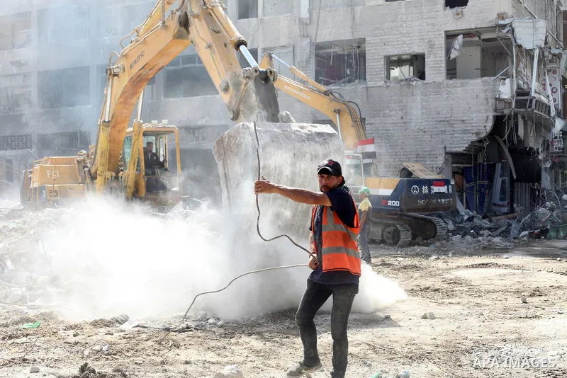 Egyptian workers and bulldozers sent from Egypt help to remove the rubble of Shorouq tower destroyed by Israeli air strikes on May, in Gaza City on July 03, 2021. Palestinian group Hamas said it will not accept any delay...