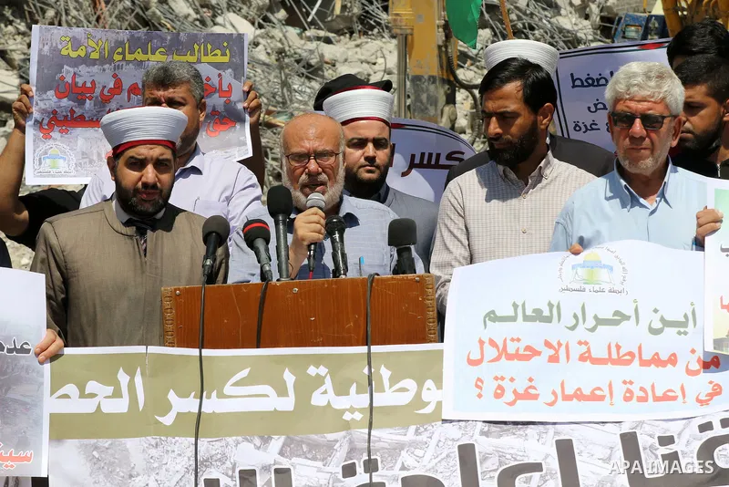 Members of the Palestine Scholars Association, attend a press conference to demand reconstruction and the entry of building materials, in front of Jala' Tower which destroyed which destroyed on May 15 during Israeli air-...