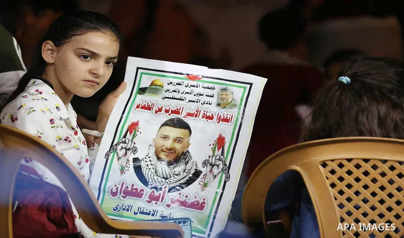 Palestinians hold placards during a protest in solidarity with prisoner in Israeli jails Ghadanfar Abu Atwan, in the West Bank city of Hebron on July 4, 2021. Palestinian prisoner in Israeli jails, Ghadanfar Abu Atwan, c...