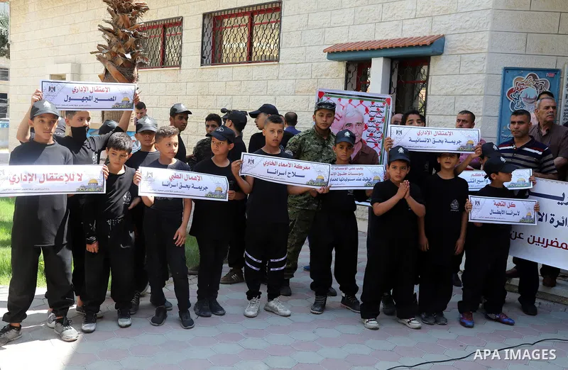 Palestinians hold placards during a protest in solidarity with prisoner in Israeli jails Ghadanfar Abu Atwan, in Gaza city on July 6, 2021. Palestinian prisoner in Israeli jails, Ghadanfar Abu Atwan, continues his hunger...