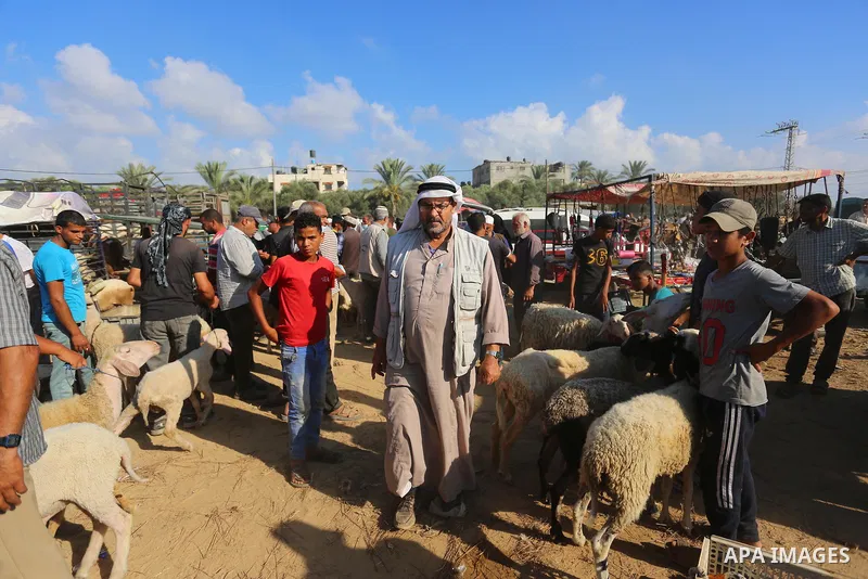 Palestinians gather at a livestock market, ahead of Eid al-Adha in Deir al-Balah, in the center of the Gaza Strip on July 06, 2021. Eid al-Adha, or the feast of sacrifice, falls at this month when Muslims will slaughter...