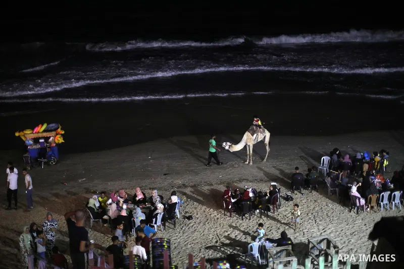 Palestinians enjoy the beach of the Mediterranean sea in Deir al-Balah in the center of Gaza Strip, on July 06, 2021. The beach is one of the few open public spaces in this densely populated city. Photo by Ashraf Amra