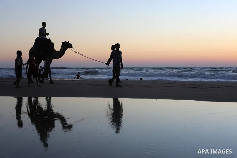 Palestinians enjoy the beach of the Mediterranean sea in Deir al-Balah in the center of Gaza Strip, on July 06, 2021. The beach is one of the few open public spaces in this densely populated city. Photo by Ashraf Amra