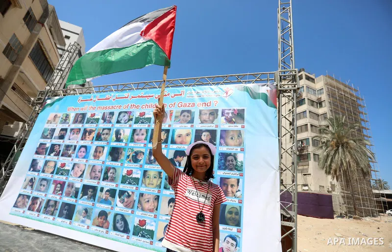 Palestinian children hold helium balloons as they take part in a rally, in front of Kolk family house which was destroyed by Israeli air strike, in Gaza city, on July 7, 2021. Children from Gaza send messages to the coun...