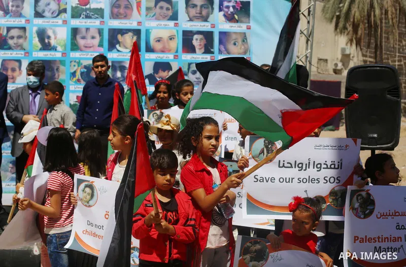 Palestinian children hold helium balloons as they take part in a rally, in front of Kolk family house which was destroyed by Israeli air strike, in Gaza city, on July 7, 2021. Children from Gaza send messages to the coun...
