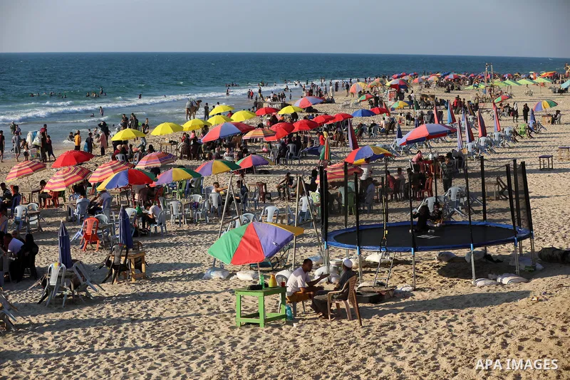 Palestinians enjoy the beach of the Mediterranean sea in Deir al-Balah in the center of Gaza Strip, on July 09, 2021. The beach is one of the few open public spaces in this densely populated city. Photo by Ashraf Amra