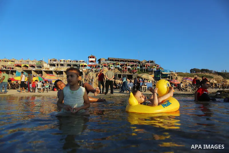 Palestinians enjoy the beach of the Mediterranean sea in Deir al-Balah in the center of Gaza Strip, on July 09, 2021. The beach is one of the few open public spaces in this densely populated city. Photo by Ashraf Amra