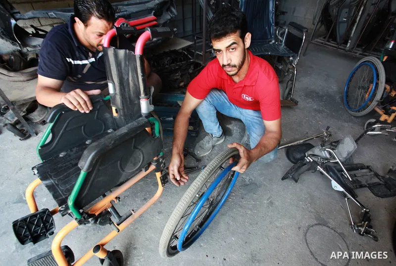 Palestinian youths work in wheelchairs repair at their workshop, in Gaza City, on July 10, 2021. A youth initiative to repair wheelchairs for people with disabilities free of charge in the Gaza Strip. 93 Thousands Person...