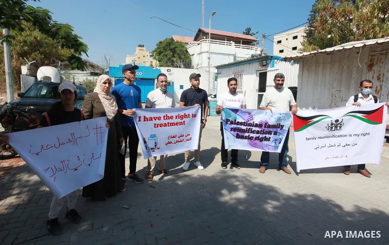 Palestinians hold IDs and banners to demand of the family unification, in front of the headquarter United Nation "UNSCO" in Gaza city, on July 11 2021. Israeli laws and policies prevent the reunification of families betw...