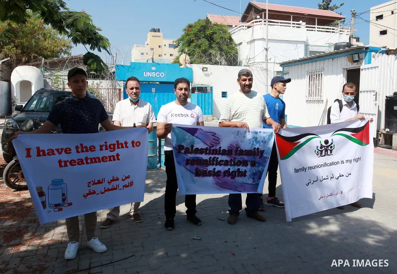 Palestinians hold IDs and banners to demand of the family unification, in front of the headquarter United Nation "UNSCO" in Gaza city, on July 11 2021. Israeli laws and policies prevent the reunification of families betw...