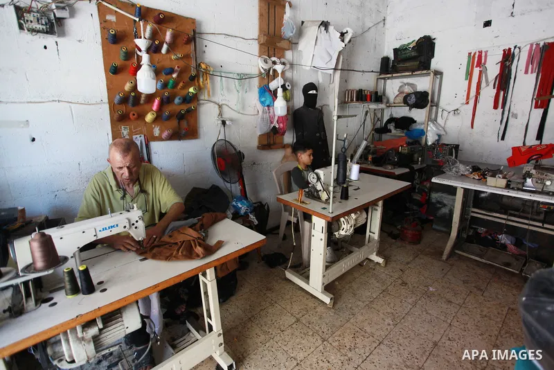 Palestinian boy Ahmed Abbas, 13, works at his father's sewing workshop at the Shati refugee camp in Gaza City, July 12, 2021. Ahmed has become the youngest tailor or fashion designer in the Gaza Strip. Abbas has mastered...