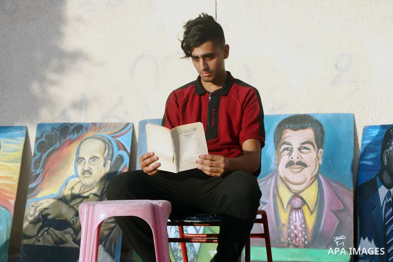 Palestinian Mohammad Saqr, 23, and Islam el-Alool, 19, set up a kiosk on the sidewalk to sell traditional foods and drinks in conjunction with practice their hobby in drawing and displaying cultural and historical books...