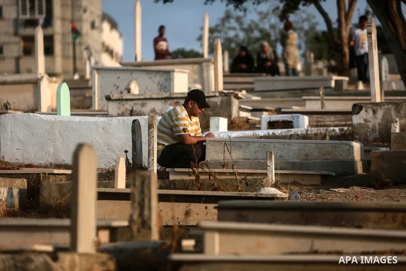 Palestinians visit the graves of their relatives at a cemetery, on the first day of Muslim holiday of Eid al-Adha in Gaza city on July 20, 2021. Eid al-Adha, or Feast of Sacrifice, Islam's most important holiday marks th...