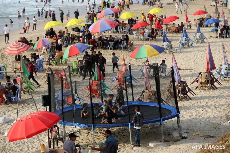 Palestinians enjoy the beach of the Mediterranean sea in Deir al-Balah in the center of Gaza Strip, during the fourth day of Eid al-adha festival on July 23, 2021. The al-Adha, or "Feast of Sacrifice", marks the end of t...