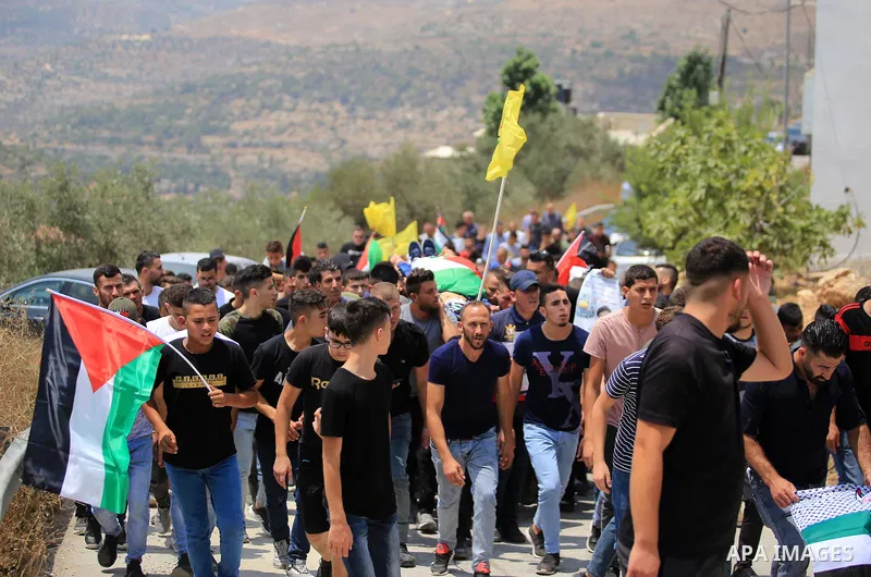 Palestinians carry the body of Muhammad Munir al-Tamimi during his funeral in Deir Nizam, west of Ramallah city in the occupied West Bank, on July 24, 2021. Al-Tamimi has died after being shot during clashes with Israeli...