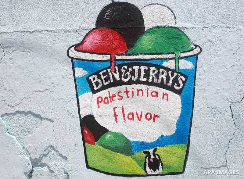 Palestinian artists paint a mural to boycott Israeli products, in Gaza city on July 29, 2021. The Ben & Jerry’s ice cream giant announced Monday that it will no longer distribute its products in the “Occupied Palestinian...