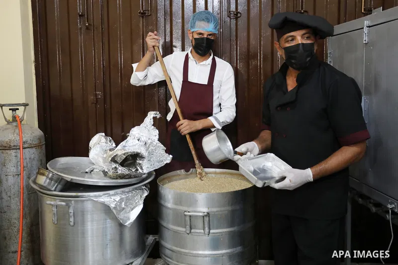 Palestinian volunteers prepare food to be distributed for free at Takiya, in Khan Younis in the southern Gaza Strip on July 29, 2021. The Takiya operates only three days a week, and serving meat, fish and chicken meals....