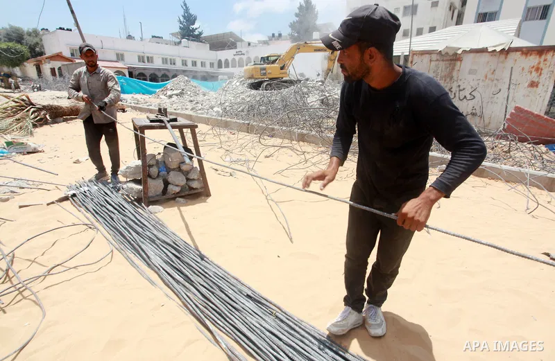 Palestinian workers recycle steel bars from a building destroyed by Israeli air strikes during the recent 11-day conflict between Isarel and Hamas on May, in Gaza city on July 29, 2021. Human Rights Watch said today that...