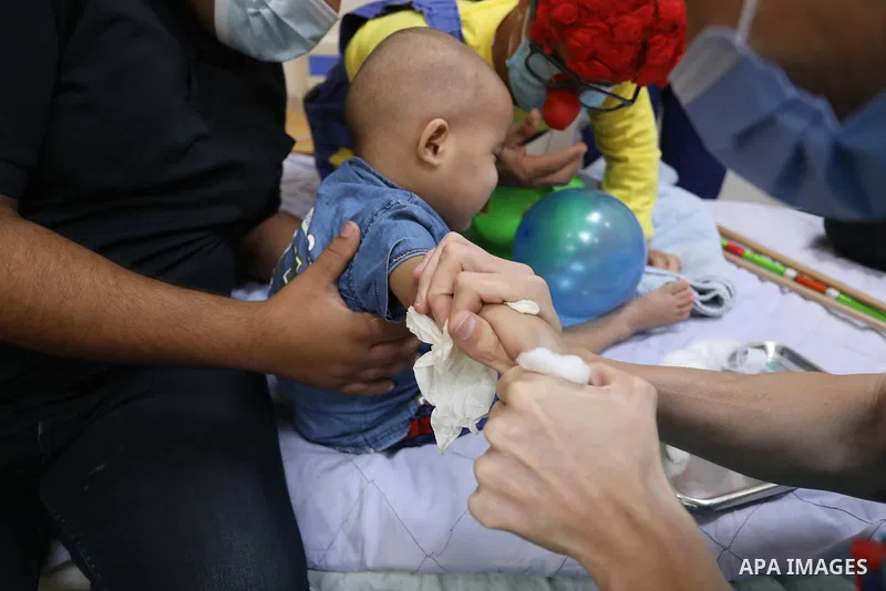 Palestinian clowns play with a child with cancer at el-Rantisi hospital in Gaza city on August 01, 2021. 2020 has been a rough year for cancer patients in the Gaza Strip. The usual restrictions and blockade were compound...