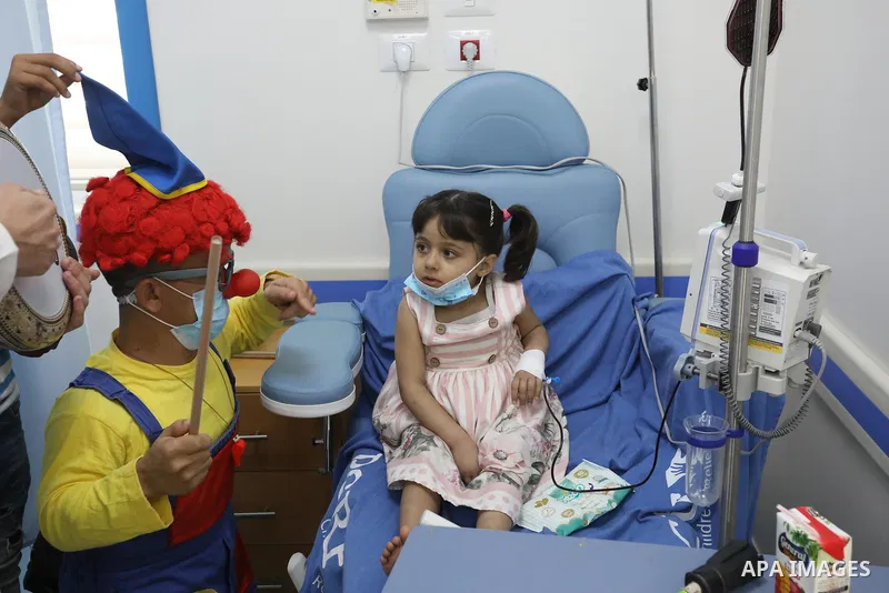 Palestinian clowns play with a child with cancer at el-Rantisi hospital in Gaza city on August 01, 2021. 2020 has been a rough year for cancer patients in the Gaza Strip. The usual restrictions and blockade were compound...
