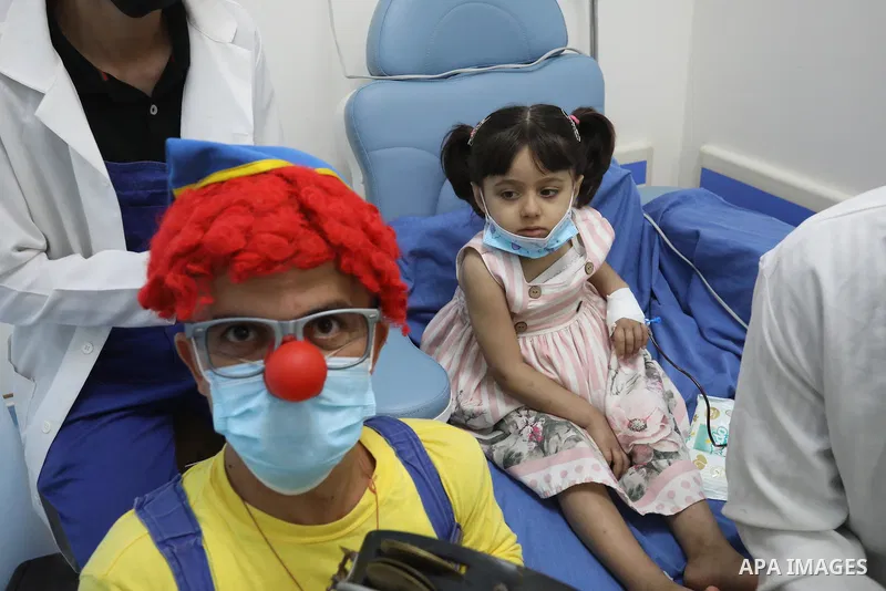 Palestinian clowns play with a child with cancer at el-Rantisi hospital in Gaza city on August 01, 2021. 2020 has been a rough year for cancer patients in the Gaza Strip. The usual restrictions and blockade were compound...
