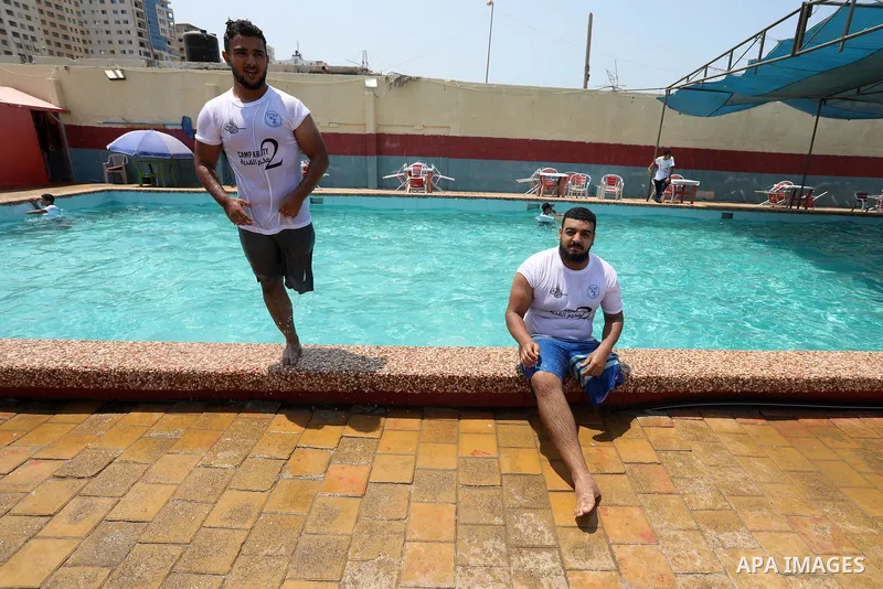 Palestinian amputee youths and children swim in a pool during a summer camp "Ability camp", in Gaza city on August 1, 2021. Photo by Ashraf Amra