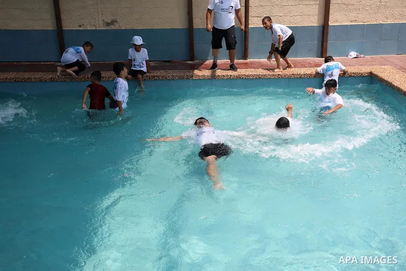 Palestinian amputee youths and children swim in a pool during a summer camp "Ability camp", in Gaza city on August 1, 2021. Photo by Ashraf Amra