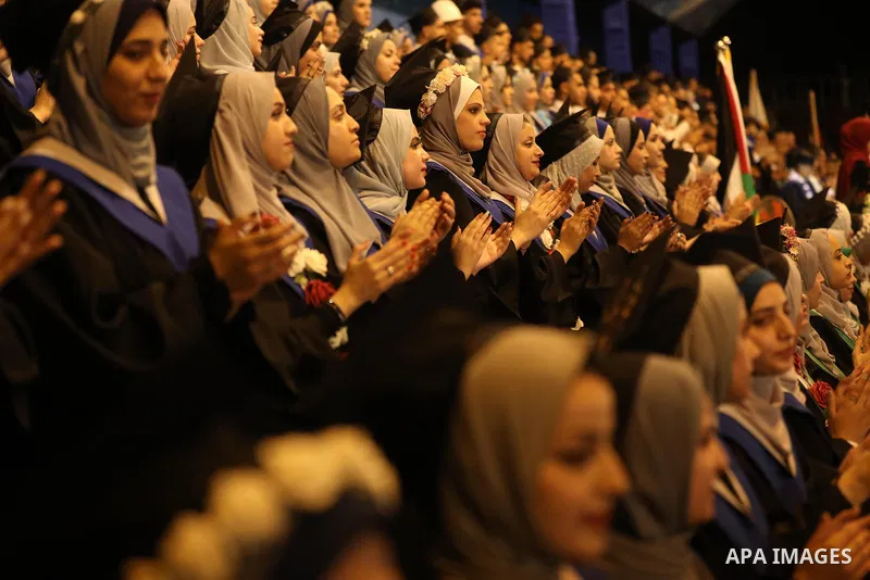 A picture taken on August 1, 2021 shows Palestinian students attend their graduation ceremony at University College of Applied Sciences (UCAS), in Gaza city. Photo by Ashraf Amra