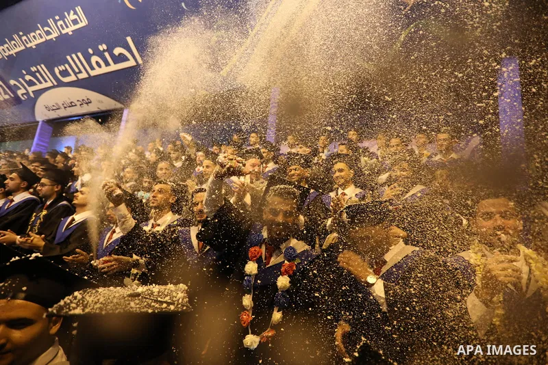 A picture taken on August 1, 2021 shows Palestinian students attend their graduation ceremony at University College of Applied Sciences (UCAS), in Gaza city. Photo by Ashraf Amra