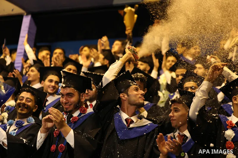 A picture taken on August 1, 2021 shows Palestinian students attend their graduation ceremony at University College of Applied Sciences (UCAS), in Gaza city. Photo by Ashraf Amra