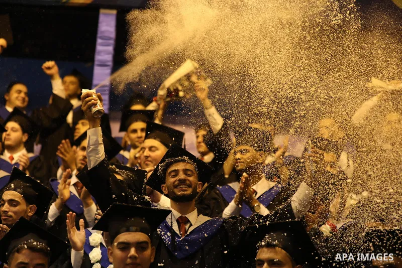 A picture taken on August 1, 2021 shows Palestinian students attend their graduation ceremony at University College of Applied Sciences (UCAS), in Gaza city. Photo by Ashraf Amra
