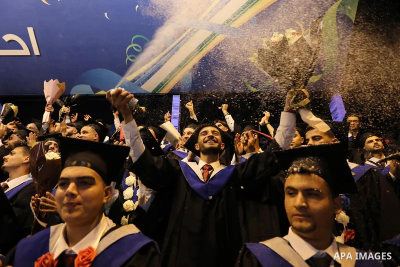A picture taken on August 1, 2021 shows Palestinian students attend their graduation ceremony at University College of Applied Sciences (UCAS), in Gaza city. Photo by Ashraf Amra