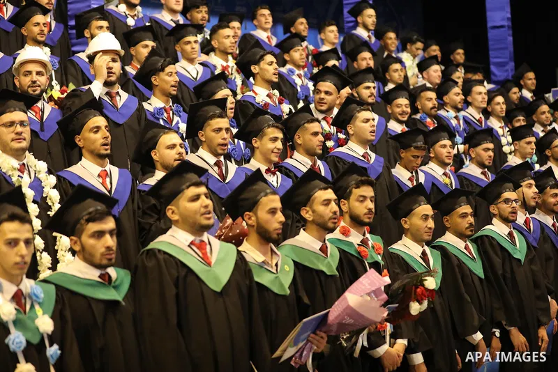 A picture taken on August 1, 2021 shows Palestinian students attend their graduation ceremony at University College of Applied Sciences (UCAS), in Gaza city. Photo by Ashraf Amra