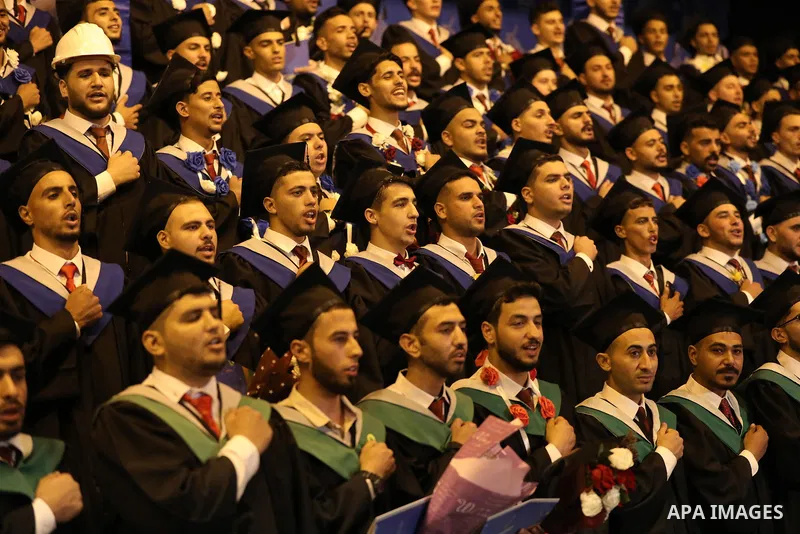 A picture taken on August 1, 2021 shows Palestinian students attend their graduation ceremony at University College of Applied Sciences (UCAS), in Gaza city. Photo by Ashraf Amra