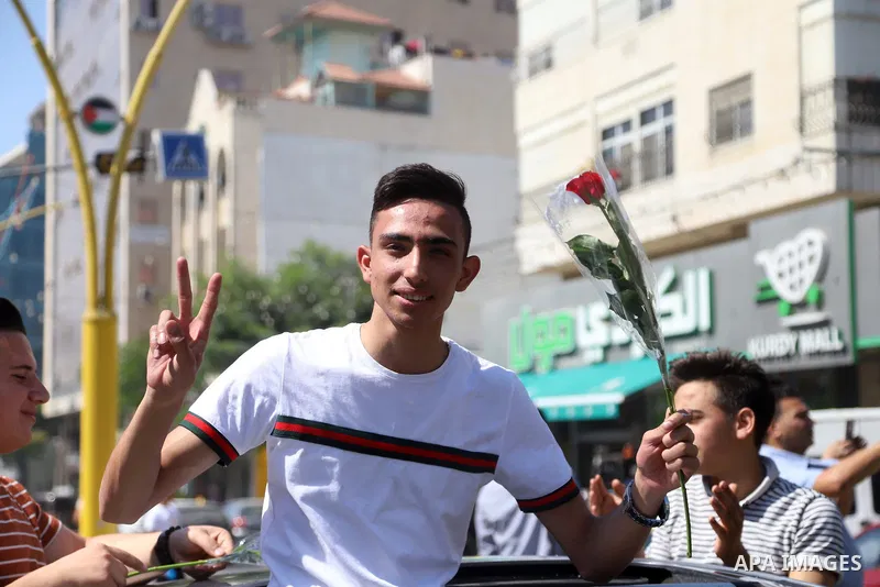 Palestinian high school students celebrate after results the final exams known as "Tawjihi", in the West Bank city of Hebron, on August 3, 2021. Photo by Ihab Alami