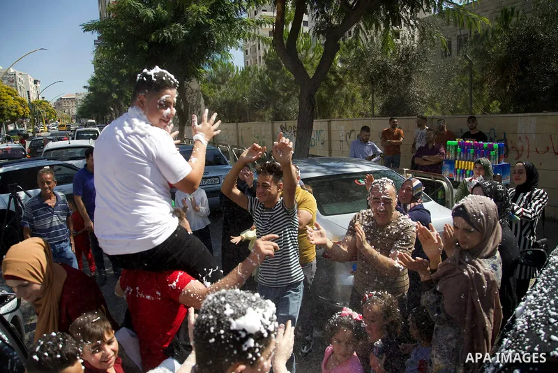 Palestinian high school students celebrate after results the final exams known as "Tawjihi", in the West Bank city of Hebron, on August 3, 2021. Photo by Ihab Alami