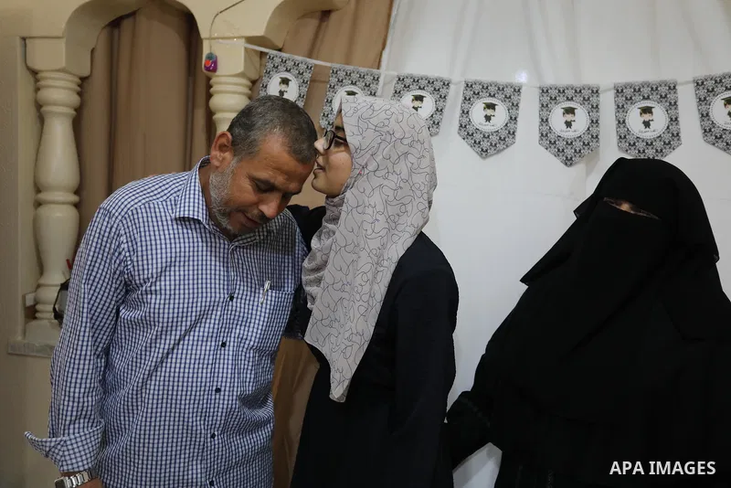 A Palestinian high school students Wafaa Amjd, 99.1%, who destroyed her family's home during the recent conflict between Israel and Hamas, celebrates with her family after her success in the final exams known as "Tawjihi...