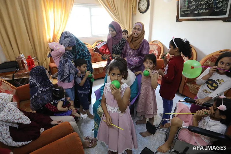 A Palestinian high school female student Rahaf Mahdi, 99.7%, celebrates with her family after her success in the final exams known as "Tawjihi", in Maghazi refugee camp in the central Gaza Strip, on August 3, 2021. Photo...